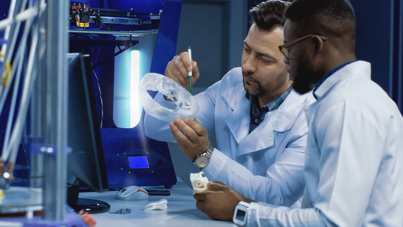 Two men looking at a part made with additive manufacturing technologies