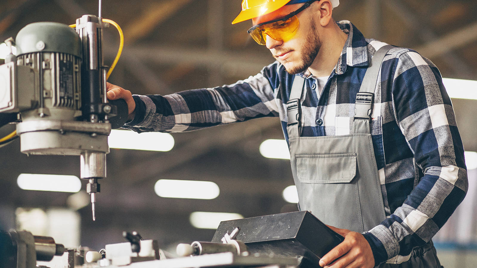 A worker in a hardhat using forging technology