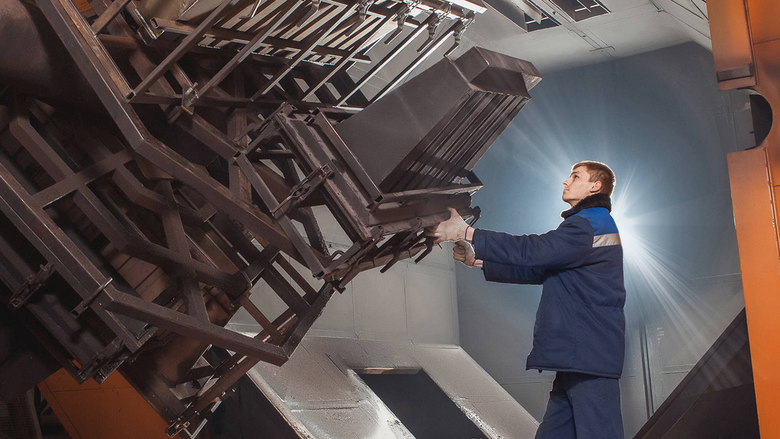 A worker interacting with a large-scale injection mold for inspection