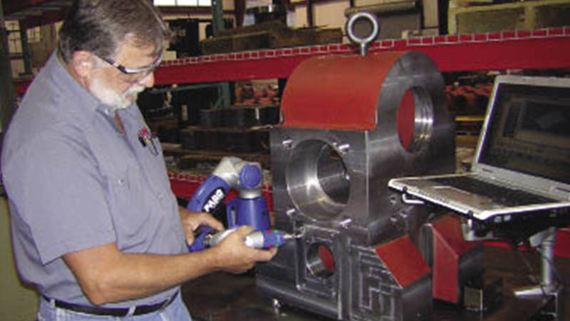 A worker using a FARO 3D laser scanner for machined parts measurement