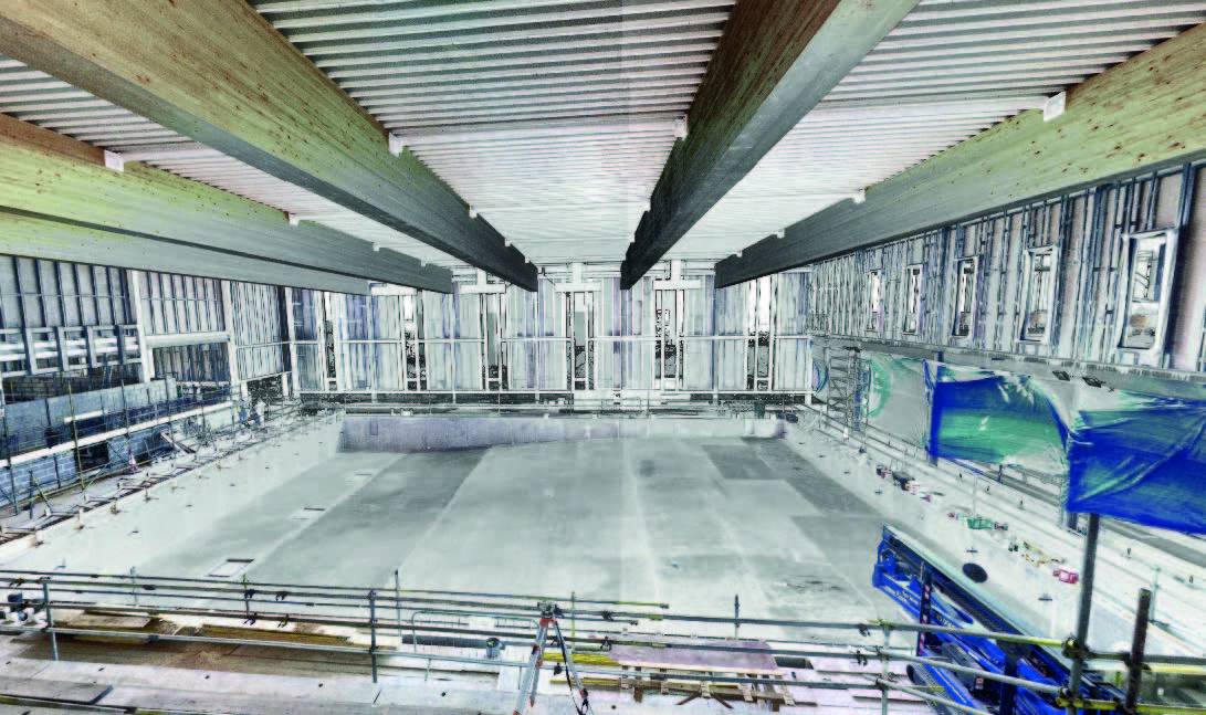 A worker's hand guiding a laser scanner along a part to ensure quality control in construction