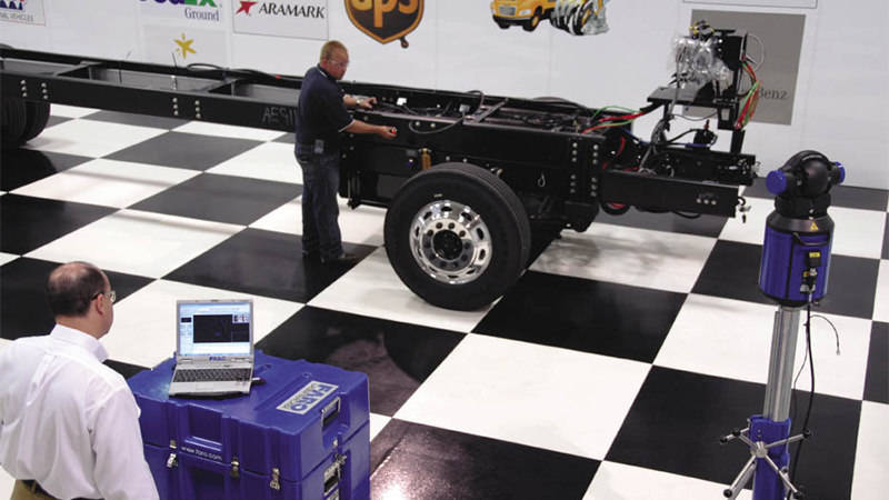 Two Freightliner workers using the FARO Vantage Laser Tracker for quality control inspection