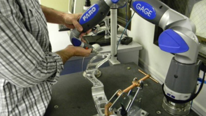 Close-up of a worker’s hands using a FARO 3D laser scanner for injection mold measurement