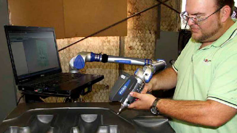 A worker uses a FARO 3D laser scanner to check a die made with forging equipment