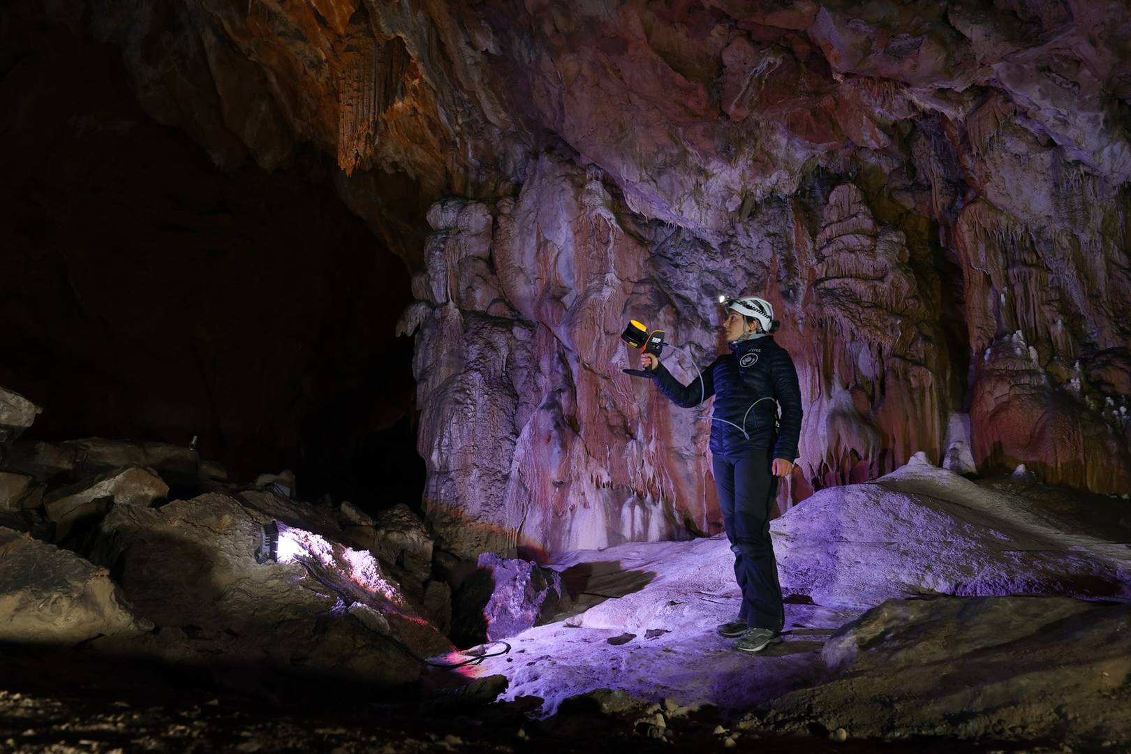 Person collecting data inside a cave using a handheld LiDAR scanner