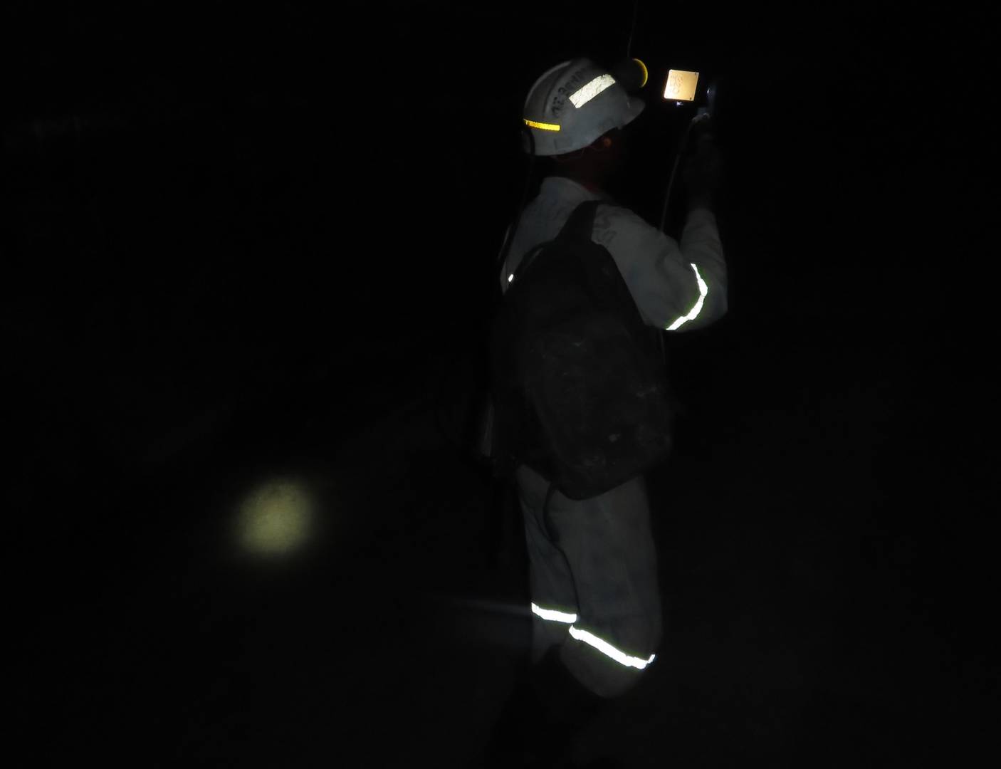 man scanning with a mobile LiDAR scanner in dark area