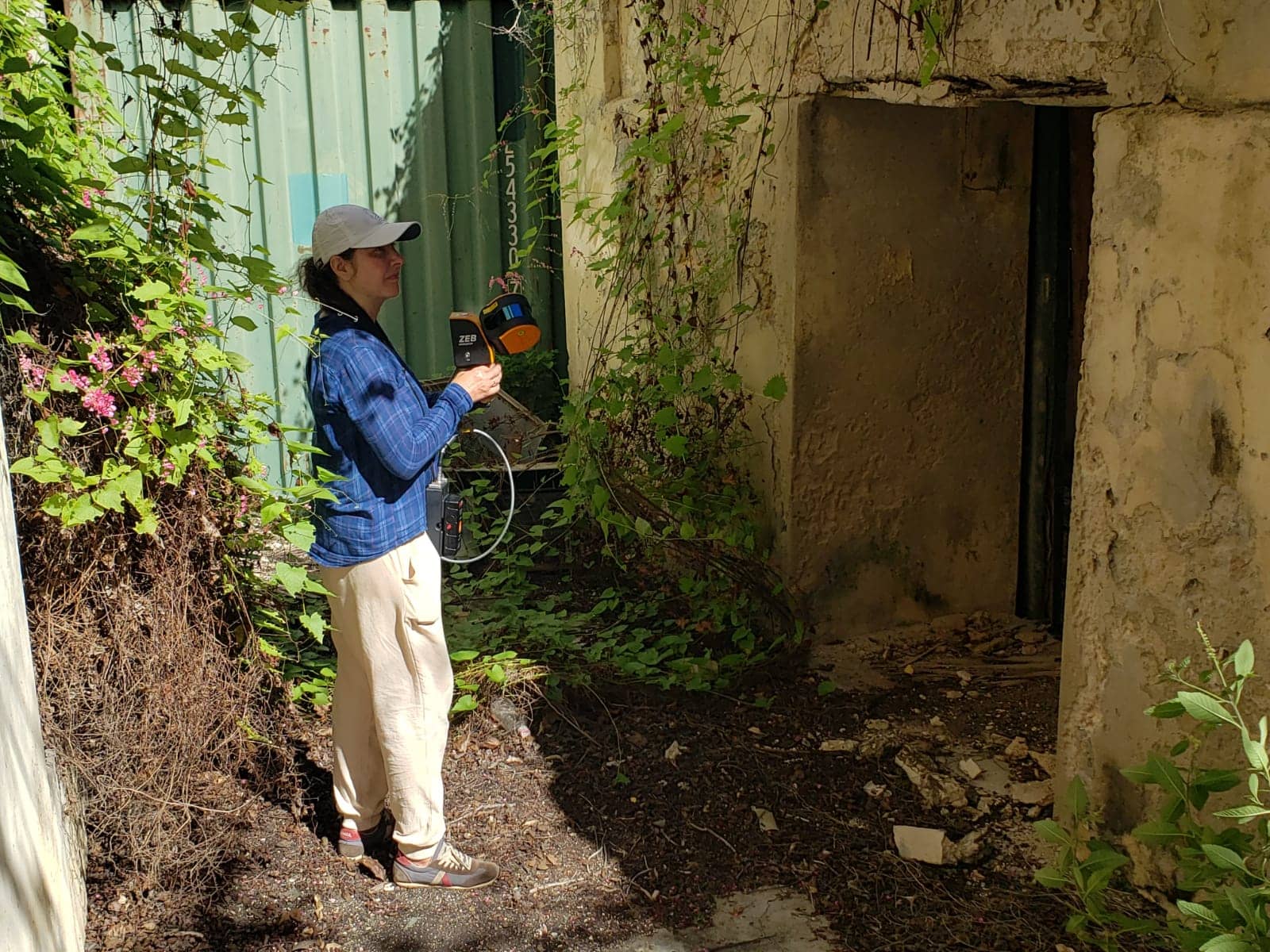 Lady mapping an abandoned building with a mobile LiDAR scanner