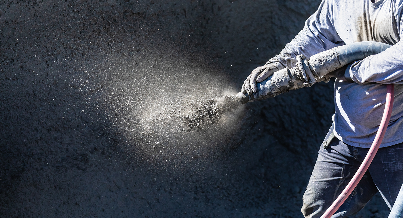 Construction Worker Shooting Concrete, Shotcrete or Gunite Through Hose