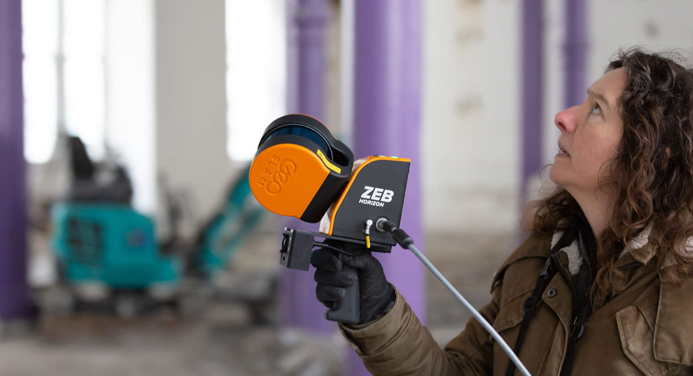Lady scanning a construction site with a mobile LiDAR scanner