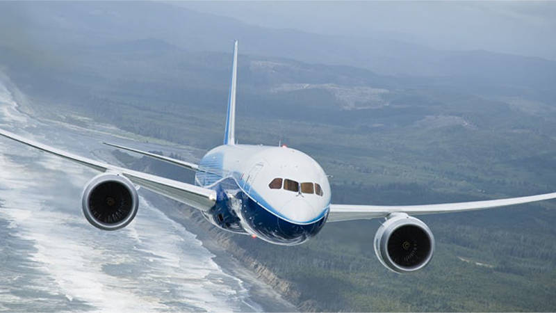 An airplane flying along a coastline