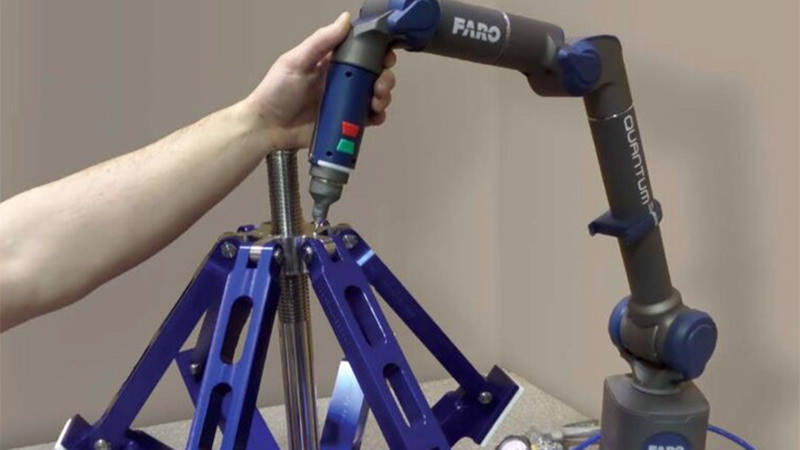 A worker's hand guiding a laser scanner along a part to ensure quality control in construction