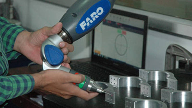 A close-up of a Unitech worker’s hands using the Gage FaroArm for 3D scanning of missile components