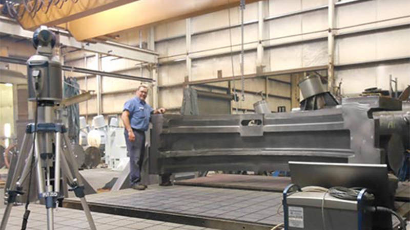 A worker at Brilex Industries standing beside a piece of heavy equipment