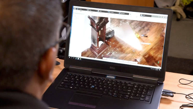 A man looking at a scan of a crime scene on a laptop for forensic investigation