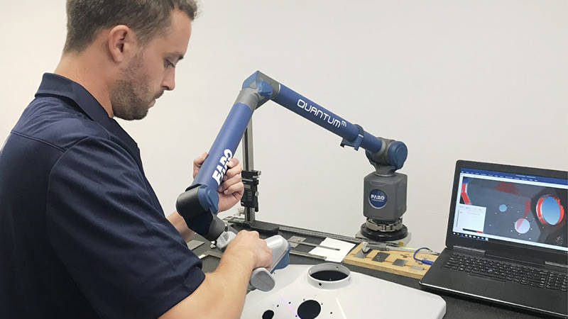 A worker using a FARO ScanArm to inspect a part for a plastic products manufacturer