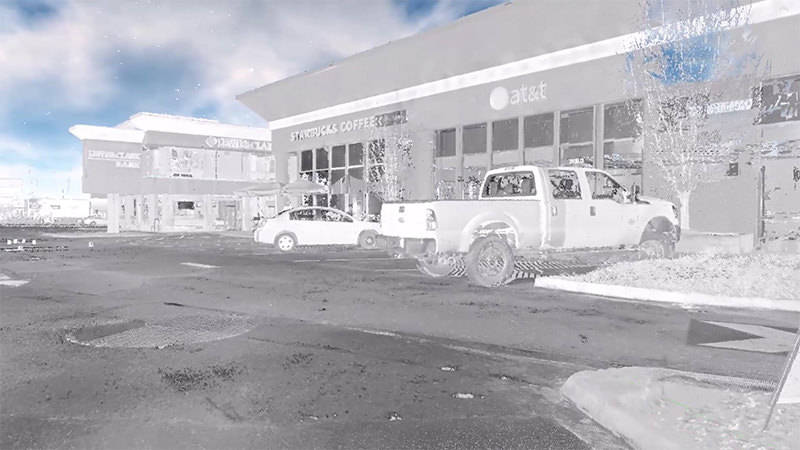 A virtual-reality image of two vehicles parked by stores, captured with 3D scanning